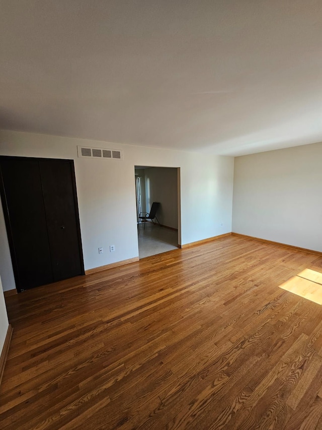 empty room with wood finished floors and baseboards