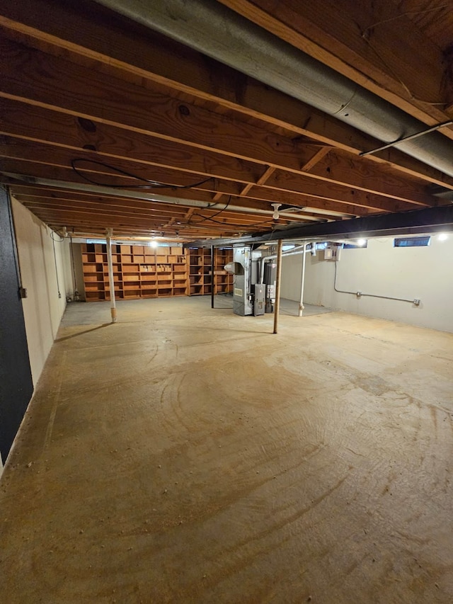 unfinished basement featuring heating unit