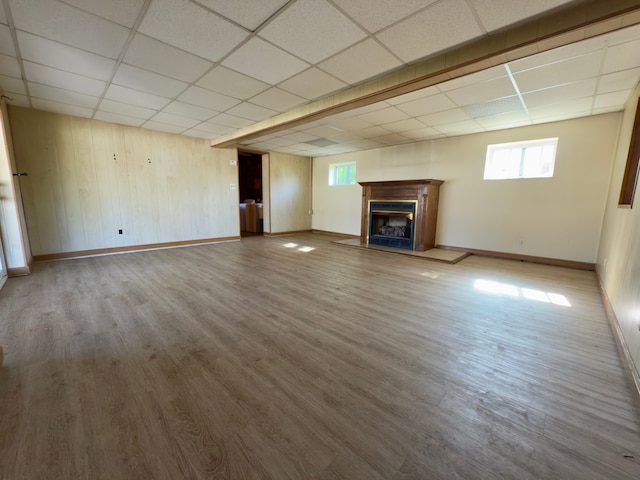 5526 Sylvia St, Dearborn Heights, MI 48125 - unfurnished living room featuring a paneled ceiling, baseboards, a fireplace with raised hearth, and wood finished floors