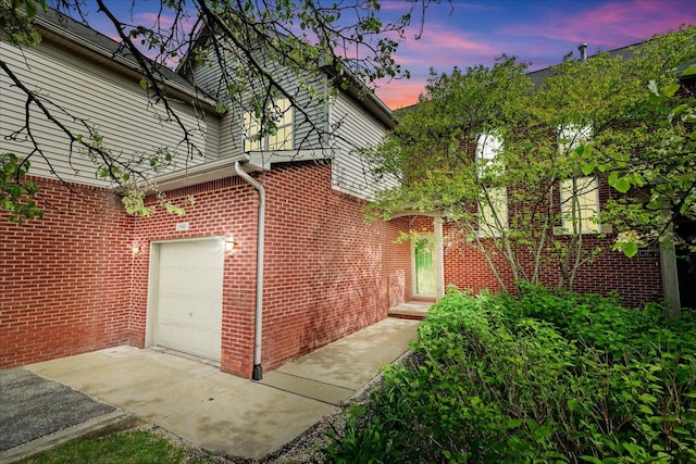 5949 High Point Ct, Brighton, MI 48116 - property exterior at dusk featuring a garage and brick siding