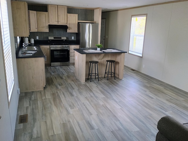 1204 Carlton Ct, Plainwell, MI 49080 - kitchen with stainless steel appliances, dark countertops, a center island, a sink, and a breakfast bar area