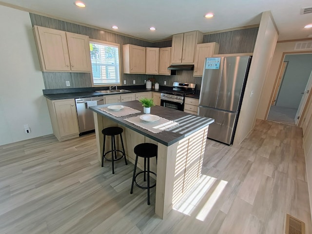 1204 Carlton Ct, Plainwell, MI 49080 - kitchen with stainless steel appliances, a sink, dark countertops, a breakfast bar area, and light brown cabinetry