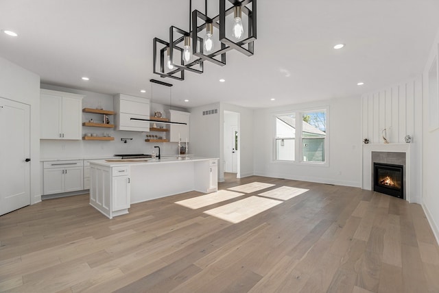 3542 Royal Ave, Berkley, MI 48072 - kitchen featuring open shelves, white cabinetry, light wood-type flooring, an island with sink, and recessed lighting
