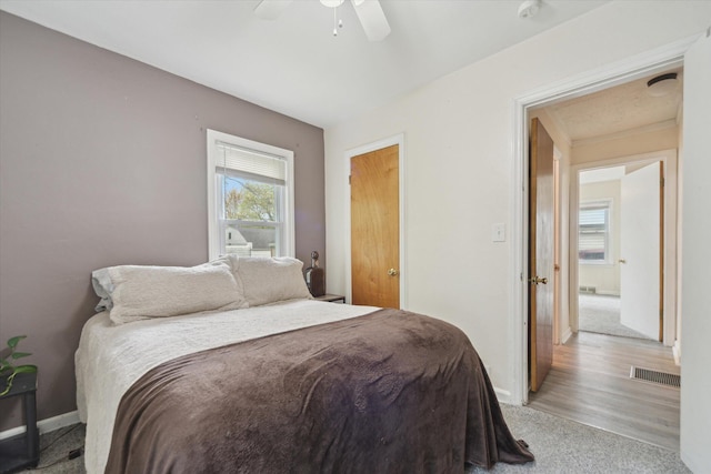 bedroom with light carpet, baseboards, and ceiling fan