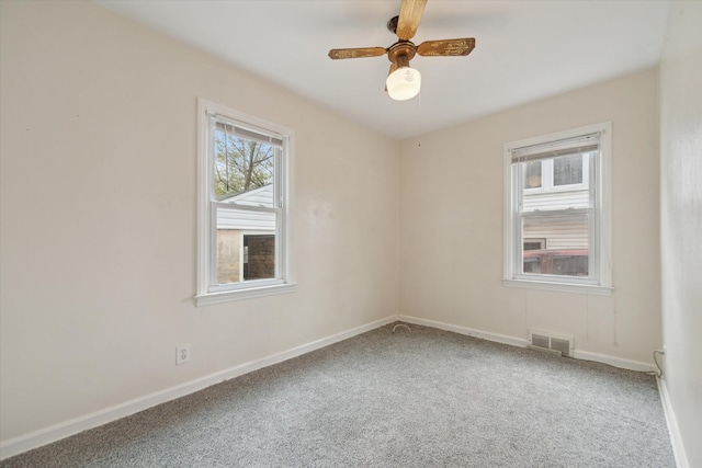 spare room featuring carpet flooring, baseboards, and a ceiling fan