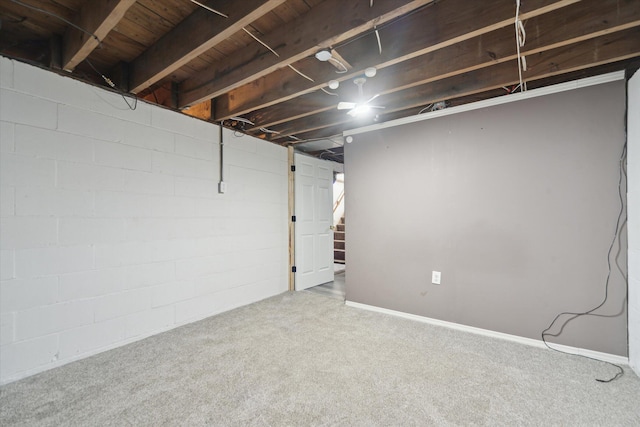 unfinished basement featuring carpet, stairs, and concrete block wall