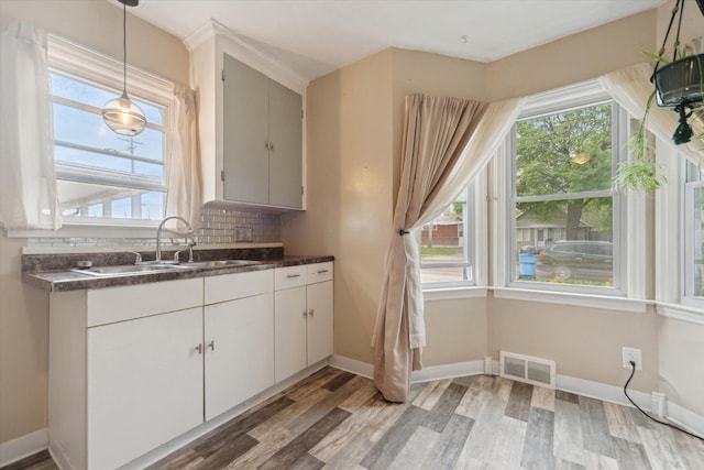 kitchen featuring a sink, dark countertops, and light wood finished floors