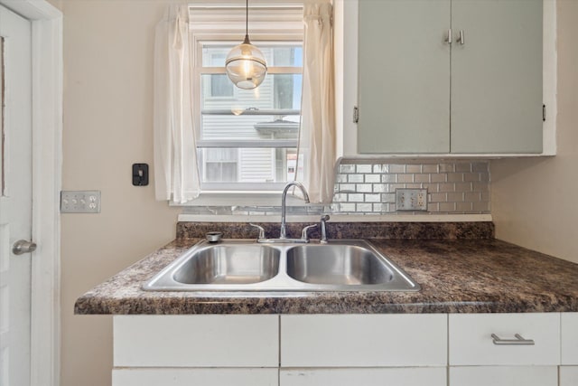 kitchen featuring a sink, dark countertops, and plenty of natural light
