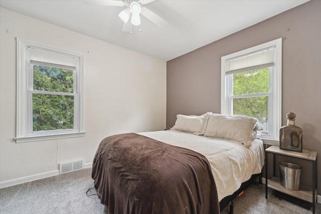 carpeted bedroom featuring multiple windows, baseboards, and ceiling fan