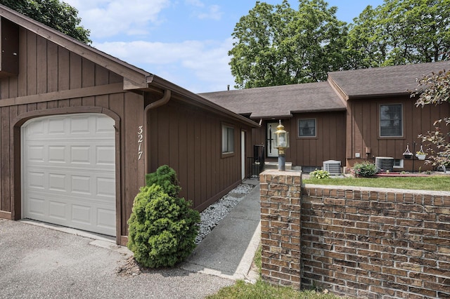 3217 Westminster Dr SE Unit 69, Grand Rapids, MI 49512 - view of property exterior featuring board and batten siding, roof with shingles, and an attached garage
