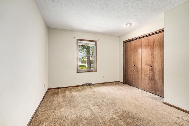 3217 Westminster Dr SE Unit 69, Grand Rapids, MI 49512 - unfurnished bedroom featuring carpet flooring, a closet, and a textured ceiling