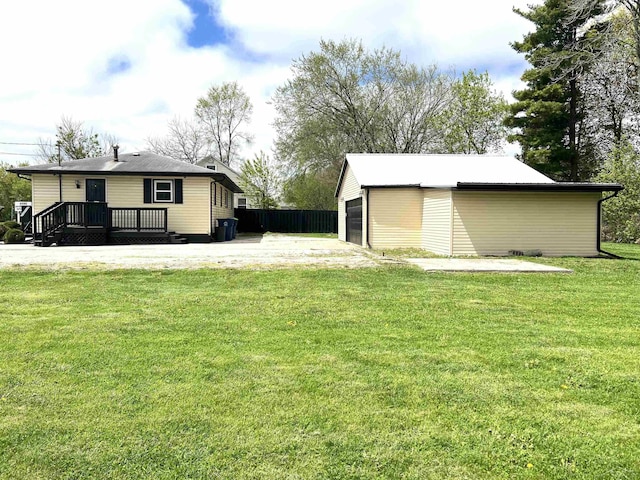 view of green lawn featuring an outbuilding and a detached garage