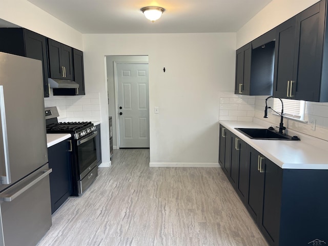 kitchen with stainless steel appliances, a sink, under cabinet range hood, and light countertops