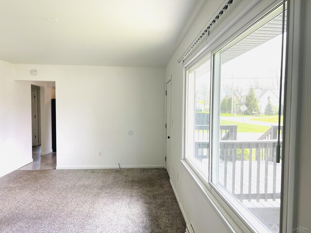 unfurnished room featuring carpet flooring and baseboards