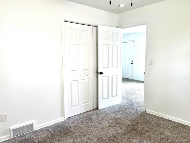 unfurnished bedroom with carpet floors, a closet, and baseboards
