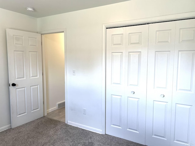 unfurnished bedroom with carpet flooring, a closet, and baseboards