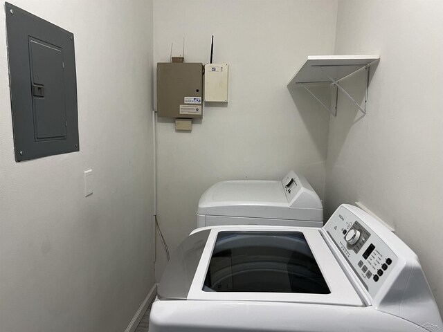 laundry area featuring electric panel, independent washer and dryer, and baseboards