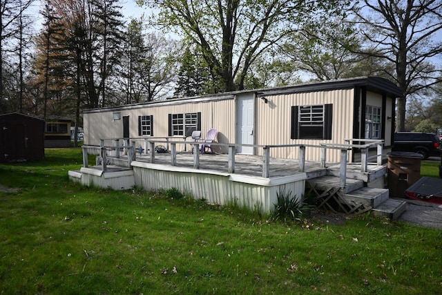rear view of house with a yard, a storage unit, a deck, and an outdoor structure