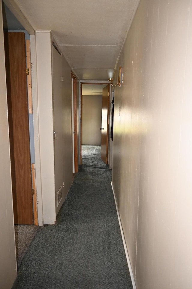 hall with dark colored carpet