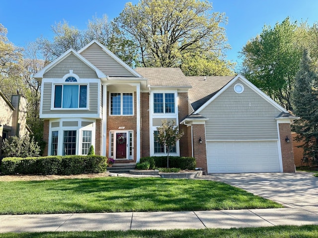 view of front of home featuring brick siding, a front yard, a garage, and driveway