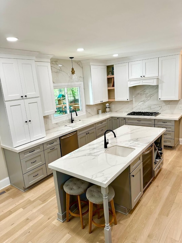 kitchen featuring gray cabinets, a sink, stainless steel dishwasher, and recessed lighting