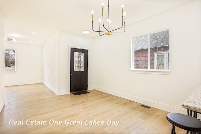 entrance foyer featuring a chandelier, wood finished floors, baseboards, healthy amount of natural light, and recessed lighting