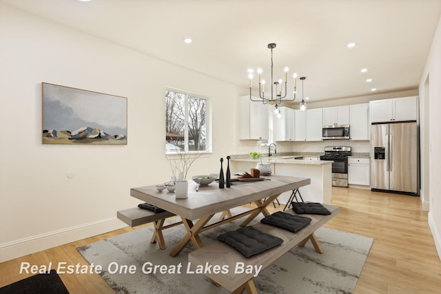dining space featuring a chandelier, recessed lighting, light wood-style floors, and baseboards