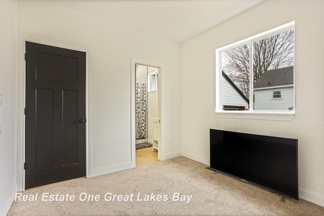 unfurnished bedroom featuring carpet flooring and baseboards