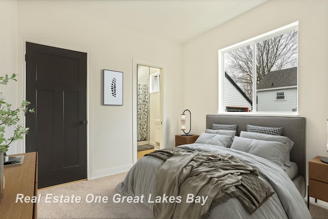 carpeted bedroom with baseboards and connected bathroom
