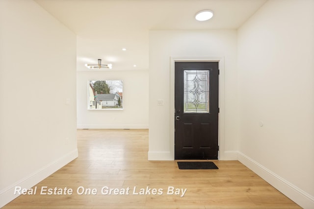 foyer featuring light wood finished floors and baseboards