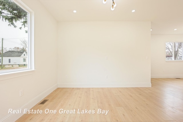 spare room featuring light wood-style floors, baseboards, and recessed lighting