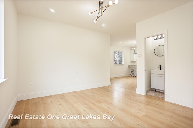 unfurnished room with a chandelier, light wood-type flooring, baseboards, and recessed lighting