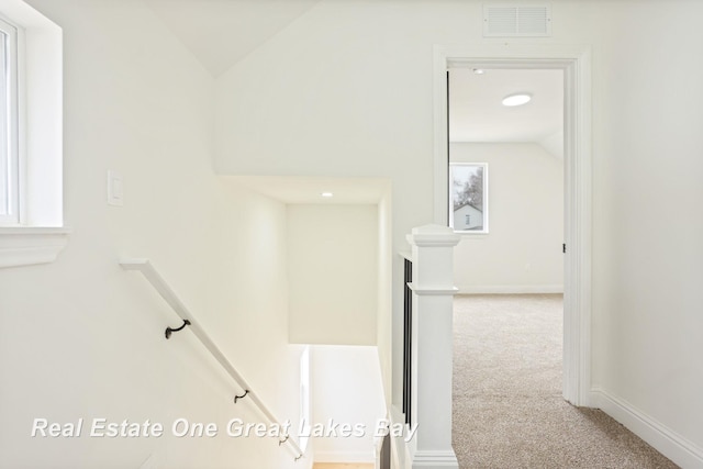 stairs with vaulted ceiling, carpet flooring, and baseboards