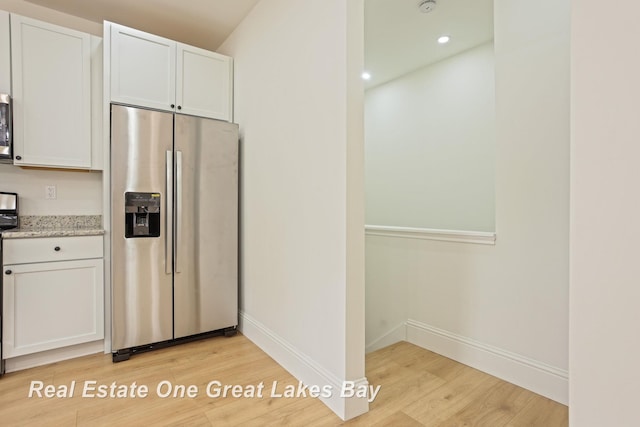 kitchen with appliances with stainless steel finishes, light wood-type flooring, baseboards, white cabinetry, and recessed lighting