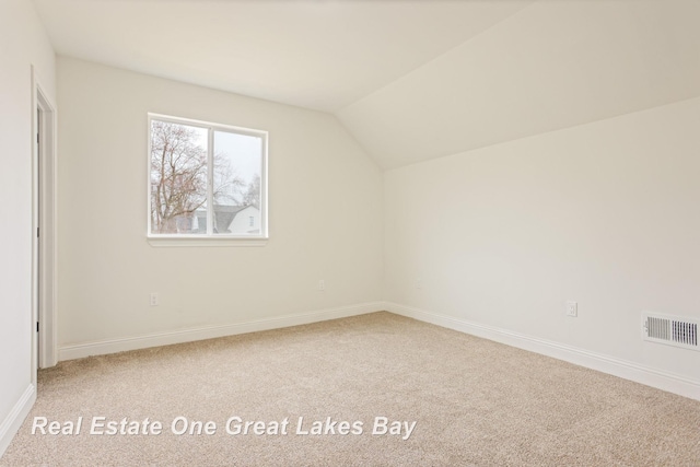 additional living space with carpet flooring, vaulted ceiling, and baseboards