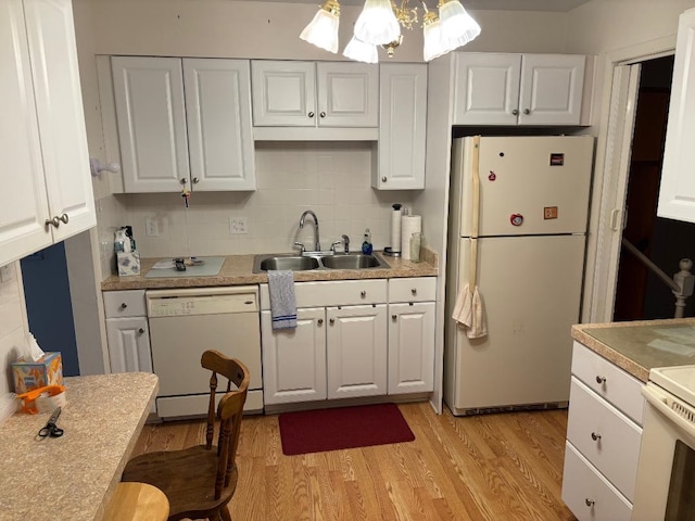 kitchen with white appliances, a sink, white cabinetry, backsplash, and light wood finished floors