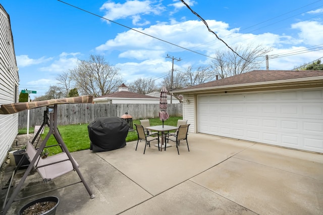 view of patio / terrace with a detached garage and outdoor dining space