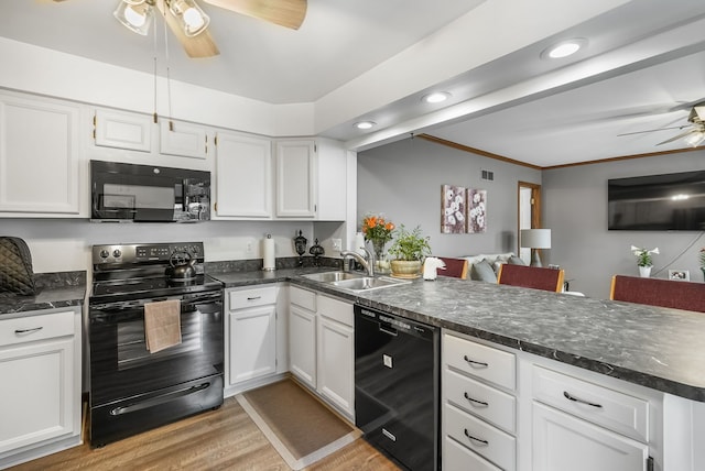 kitchen with black appliances, a ceiling fan, a sink, a peninsula, and light wood finished floors