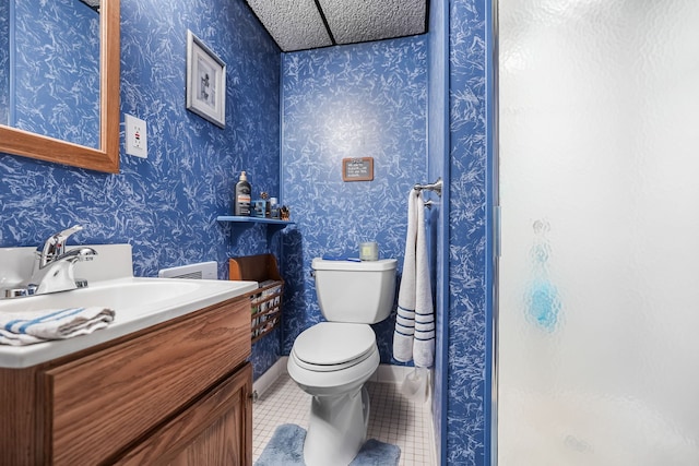 full bathroom featuring tile patterned flooring, toilet, a stall shower, vanity, and wallpapered walls