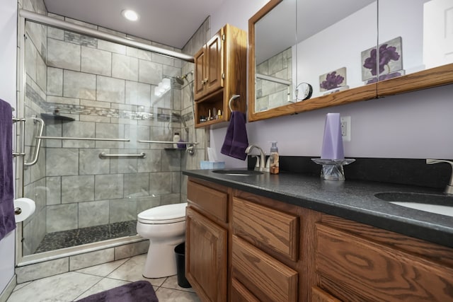 bathroom featuring a shower stall, toilet, double vanity, and tile patterned floors