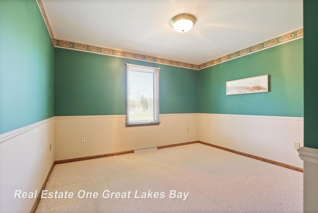 unfurnished room featuring carpet and baseboards