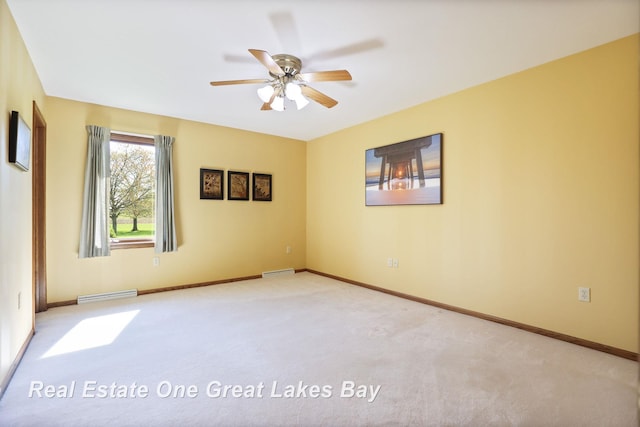 spare room with a ceiling fan, carpet floors, and baseboards