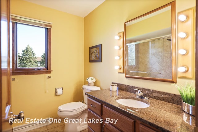 full bath with tiled shower, vanity, toilet, and tile patterned flooring