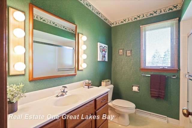 bathroom featuring a baseboard heating unit, a shower with shower door, vanity, toilet, and baseboards