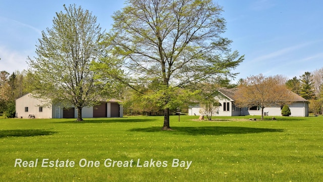 view of green lawn with a garage