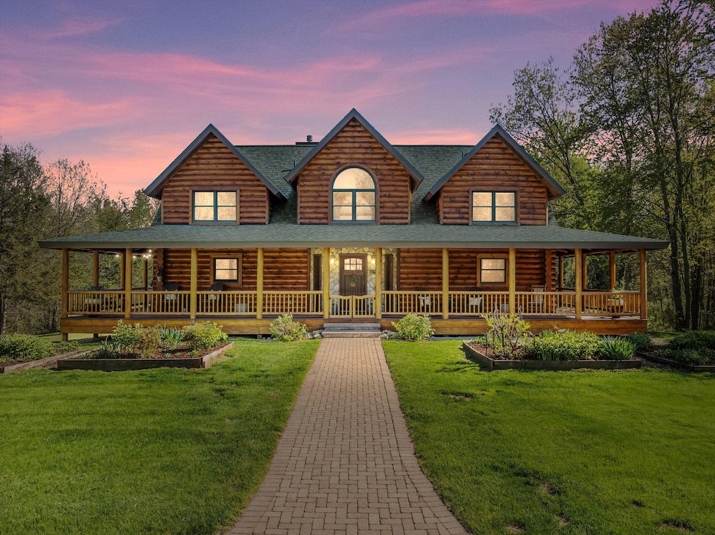 19263 Williamsville Rd, Gregory, MI 48137 - view of front of property featuring log exterior, roof with shingles, a front yard, and covered porch