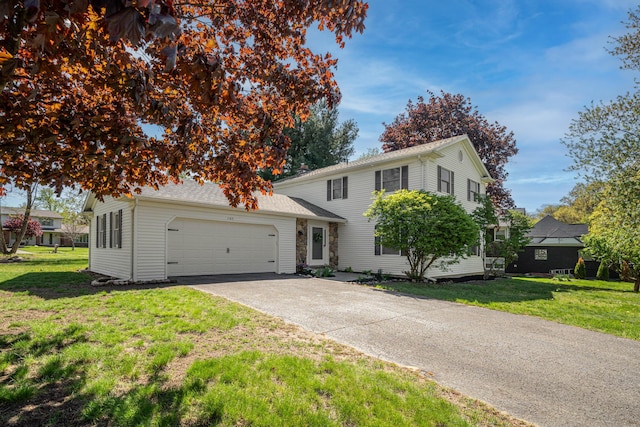 traditional home featuring a garage, driveway, and a front yard