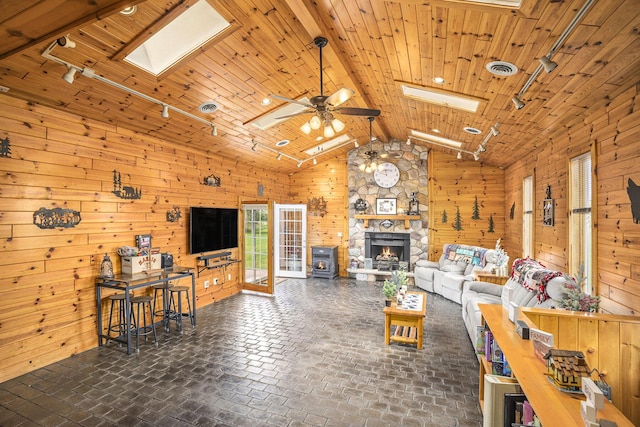 2660 Barber Rd, Grass Lake, MI 49240 - living area featuring a skylight, rail lighting, wood walls, ceiling fan, and brick patterned floors