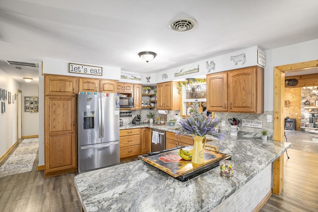 2660 Barber Rd, Grass Lake, MI 49240 - kitchen with appliances with stainless steel finishes, open shelves, a peninsula, light stone counters, and decorative backsplash