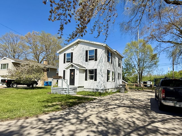 traditional-style house with driveway and a front lawn